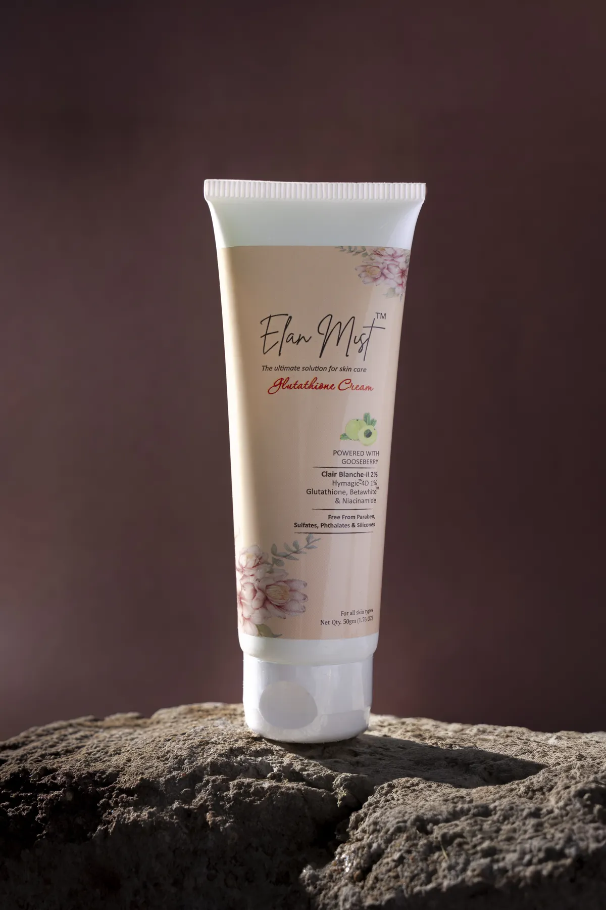 Elanmist Glutathione Cream tube standing on a natural rock
